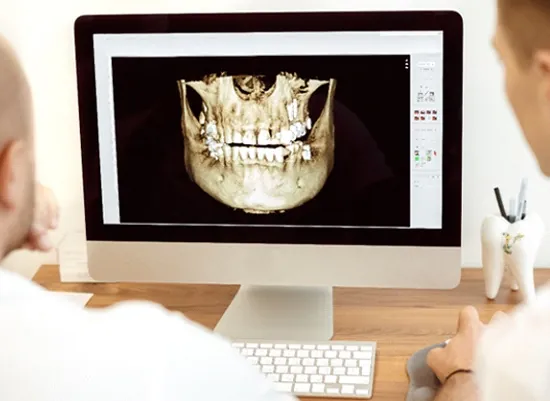 A dentist reviewing a 3D cone-beam scan with a patient