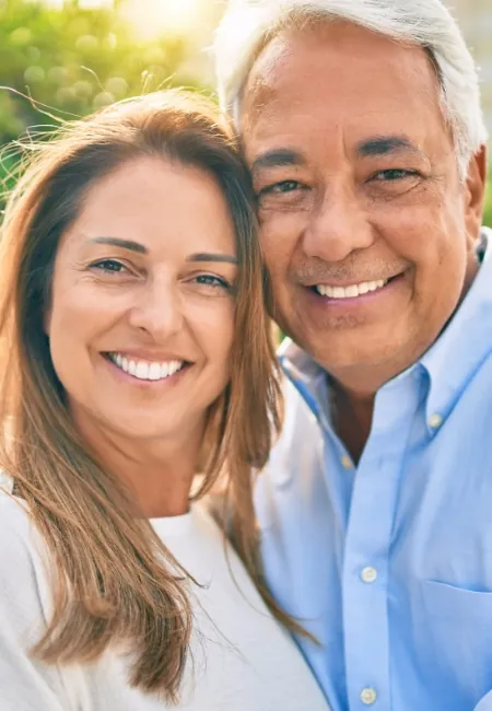 A smiling couple after dental implant treatment