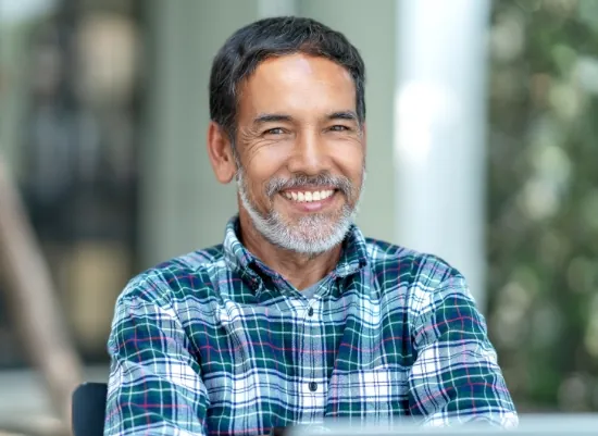 A patient smiling confidently after restorative dental treatment